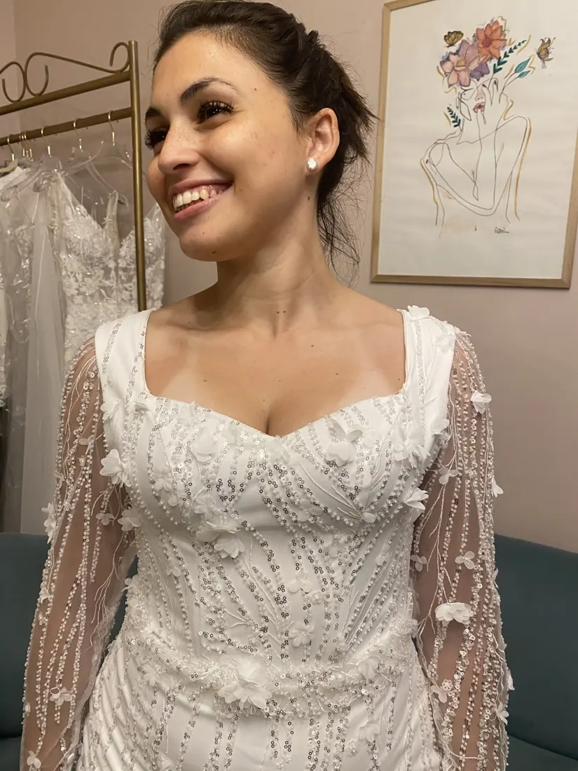 Novia sonriente con vestido bordado durante una prueba
