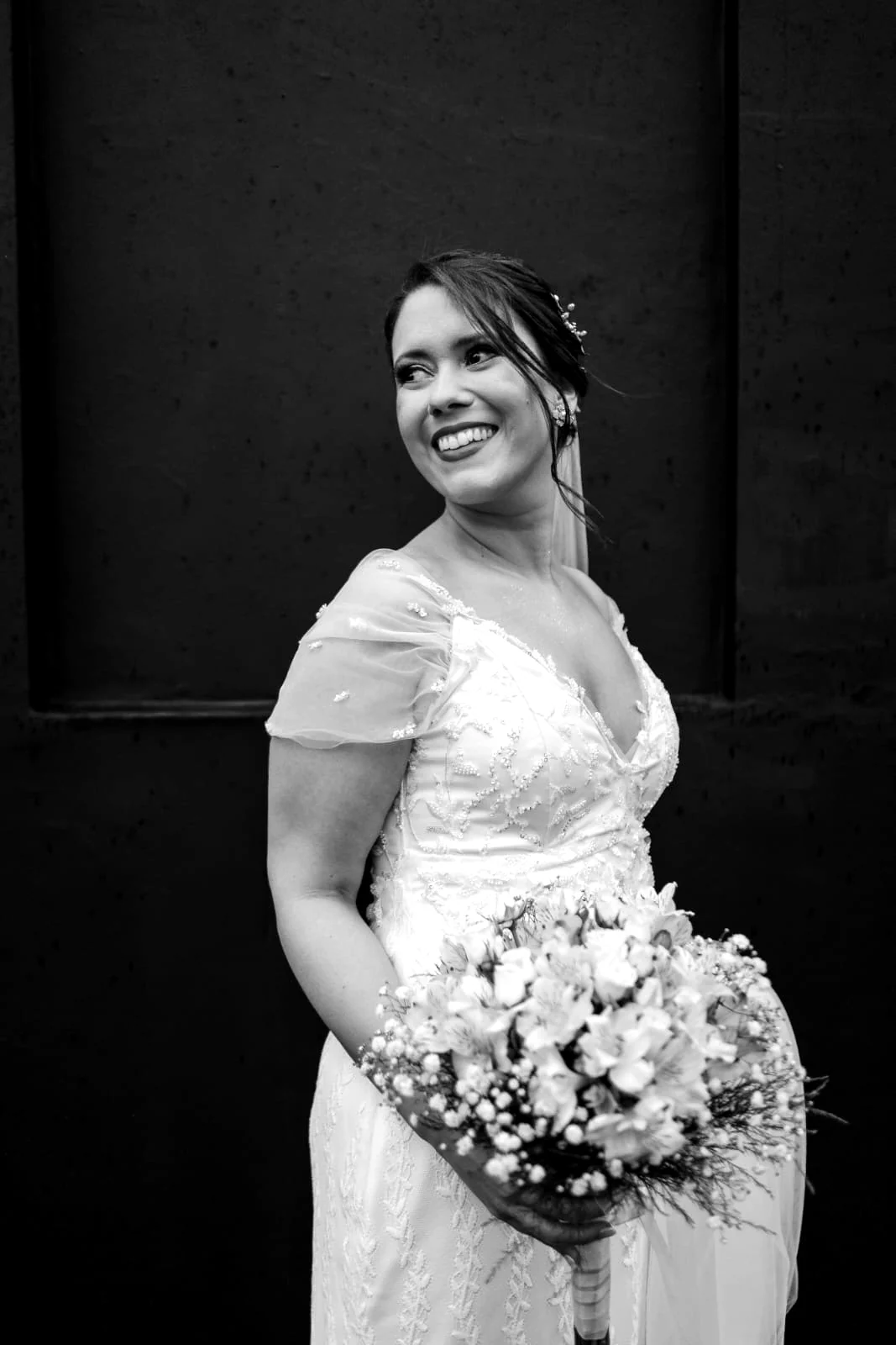 Novia sonriente con vestido bordado de Florencia Bentos y ramo de flores blancas